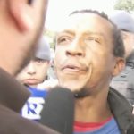 Suspeito de homicídio cospe em repórter durante abordagem na delegacia