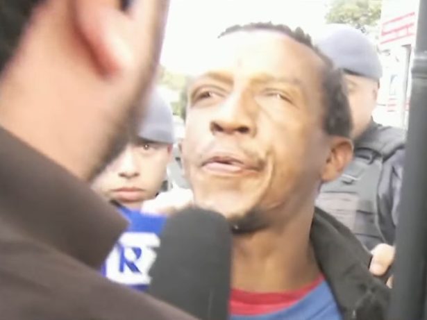 Suspeito de homicídio cospe em repórter durante abordagem na delegacia