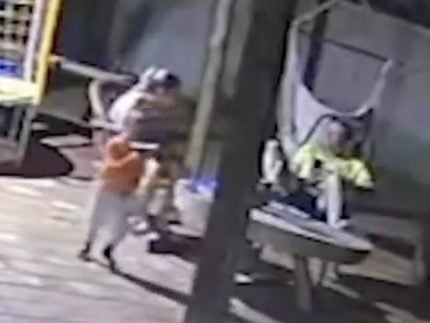 Criança de dois anos com a arma do pai