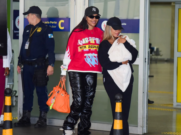 Ludmilla e Brunna desembarcam no Brasil com a filha Zuri nos braços