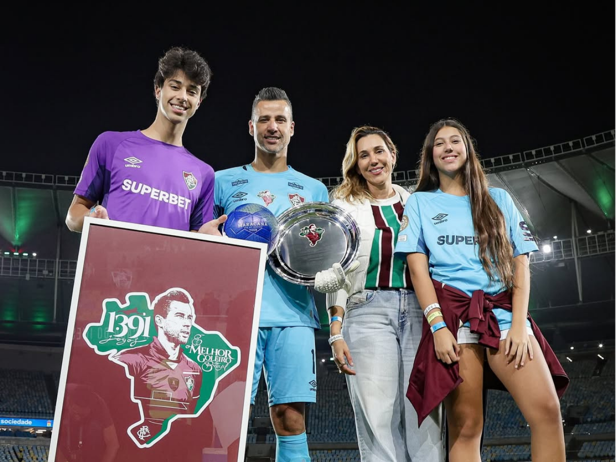 Fábio posa ao lado da família com homenagem feita pelo Fluminense após marca histórica / Foto: Marcello Gonçalves e Lucas Merçon Fábio posa ao lado da família com homenagem feita pelo Fluminense após marca histórica / Foto: Marcello Gonçalves e Lucas Merçon