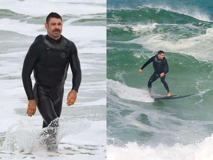 Cauã Reymond enfrenta o frio e o mar ressacado e surfa na Barra da Tijuca